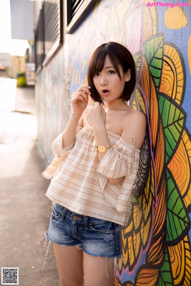 A woman standing in front of a colorful wall.