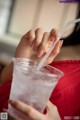 A woman holding a plastic cup with a straw in it.