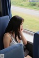 A woman sitting on a train looking out the window.