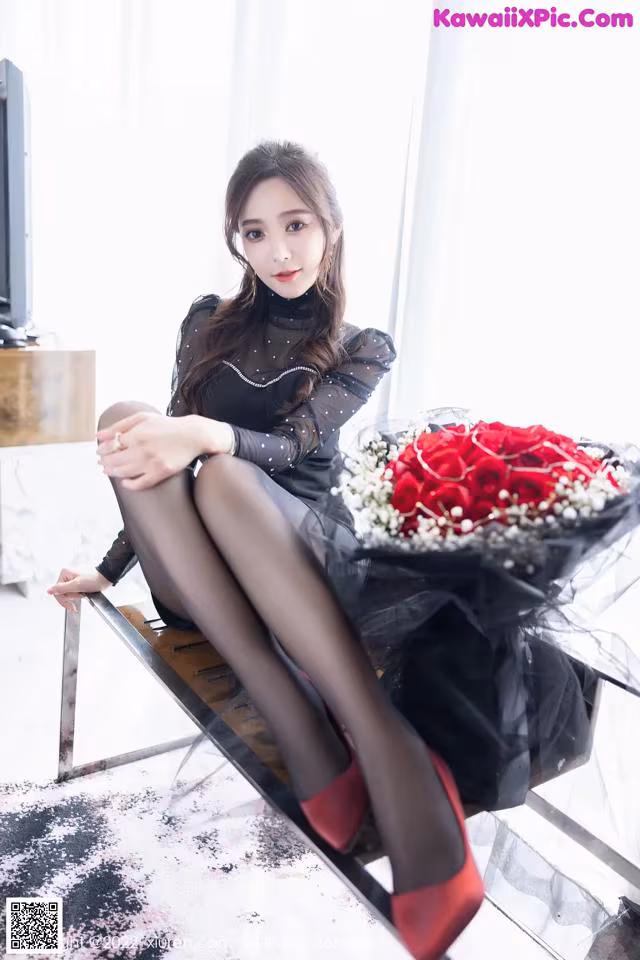 A woman sitting on a bench holding a bouquet of flowers.