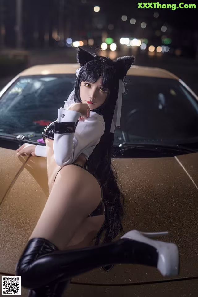 A woman in a cat costume sitting on top of a car.