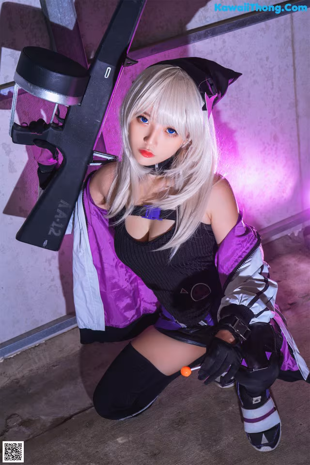A woman in a black and purple outfit holding a gun.