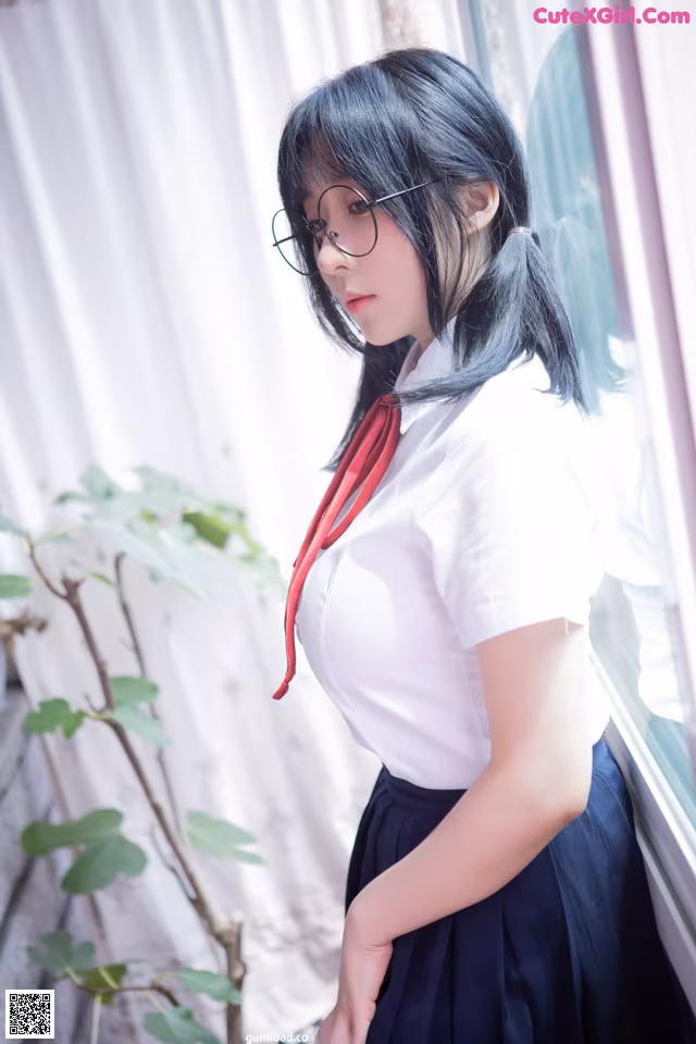 A woman in a white shirt and black skirt leaning against a window.