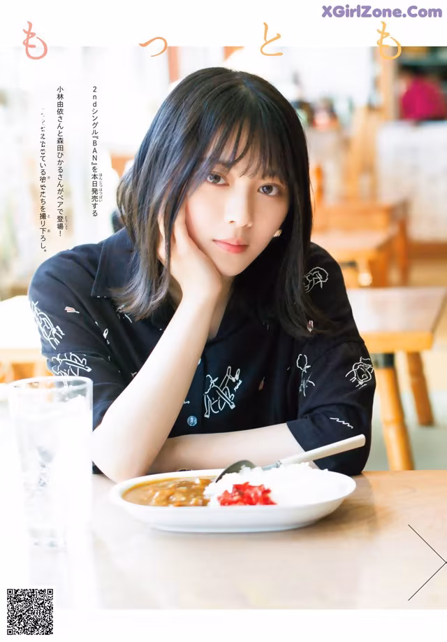 A woman sitting at a table with a plate of food.