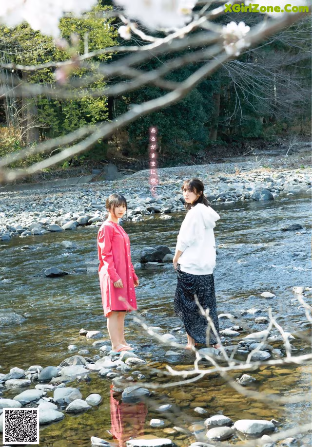 A couple of women standing next to each other in a river.