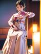 A woman in a kimono sitting on a chair.