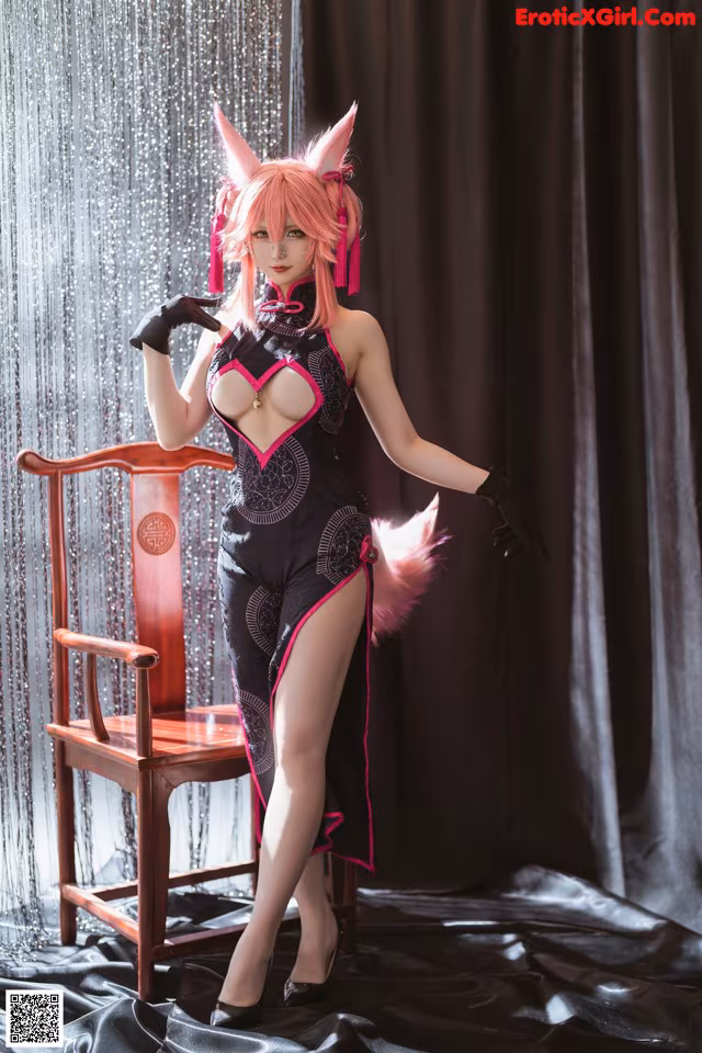 A woman in a black and pink outfit posing for a picture.