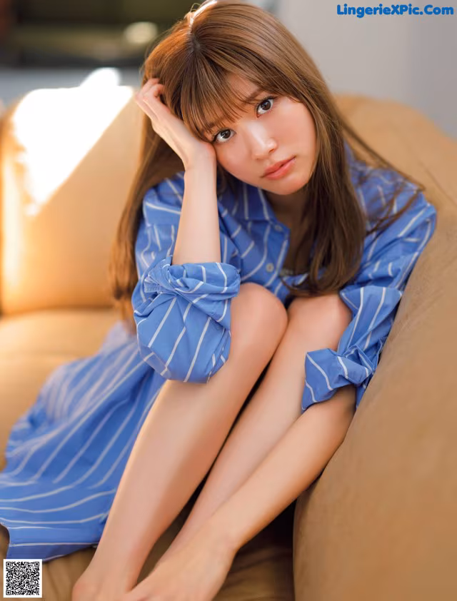 A woman sitting on a couch with her legs crossed.