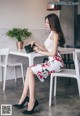 A woman sitting at a table with a purse in her hand.