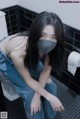 A woman wearing a face mask sitting on a toilet.